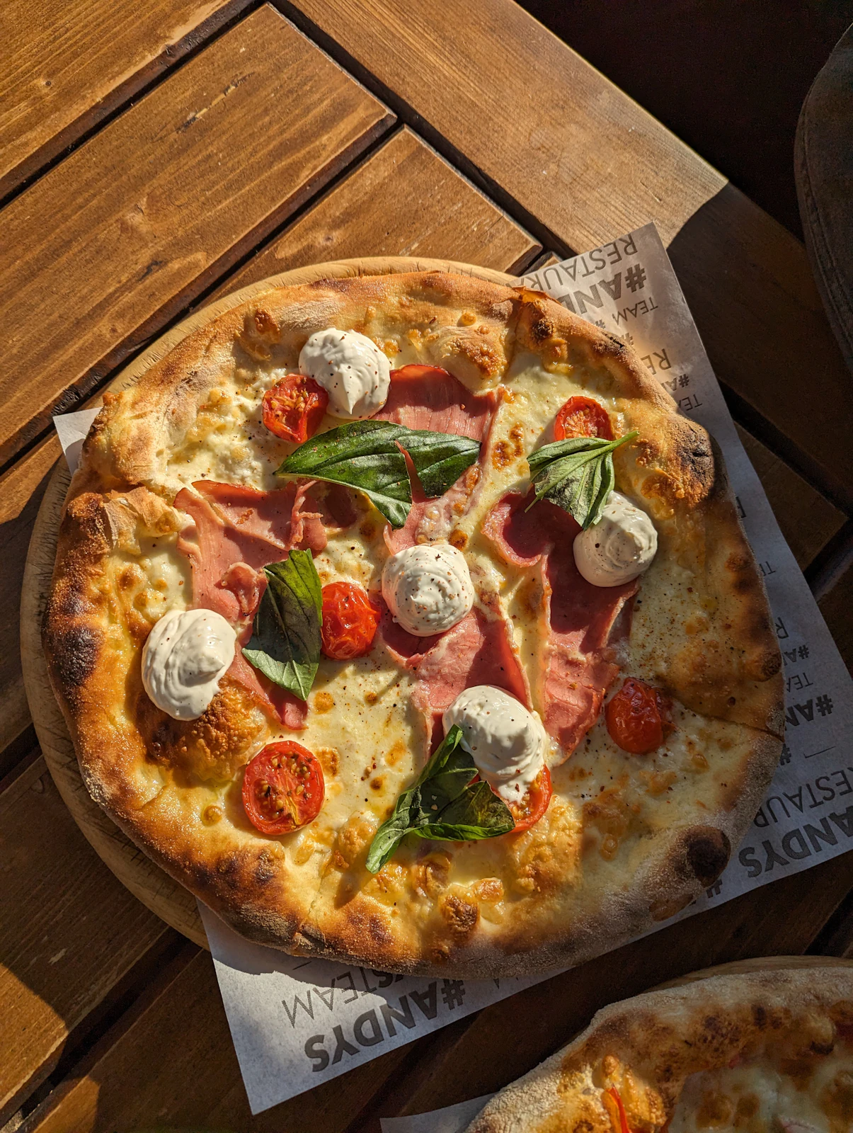 Freshly baked tomato and basil pizza on a wooden table