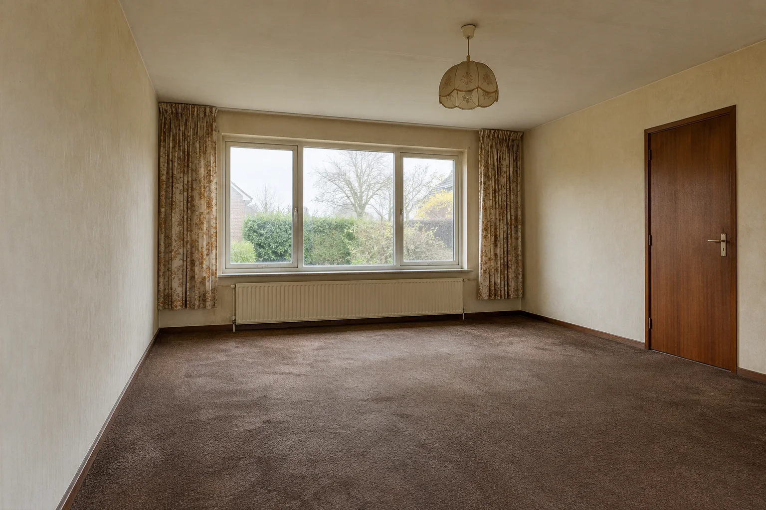 Illustrative living room before renovation, with worn carpet and dated finishes